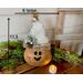This image shows a Christmas gourd elf. It is 11.5 inches tall and 6 inches wide. It is displayed on a vintage truck with Christmas greenery